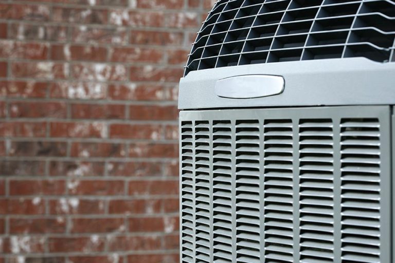Outdoor HVAC unit beside a brick wall